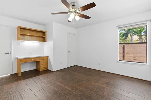 a view of an empty room with a window and a fireplace