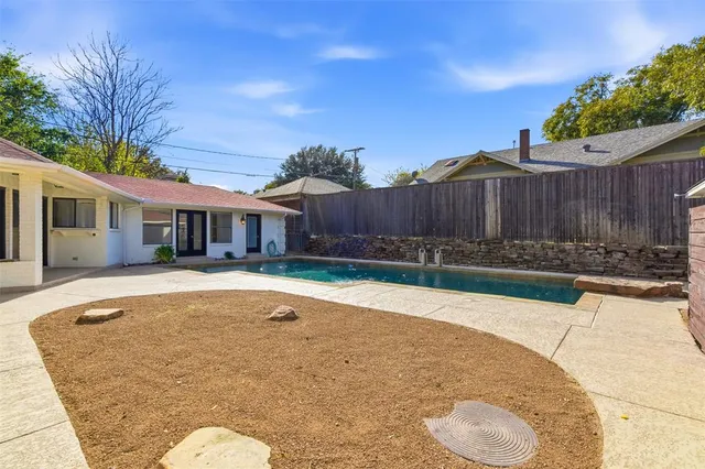 a view of pool with two chairs next to a yard
