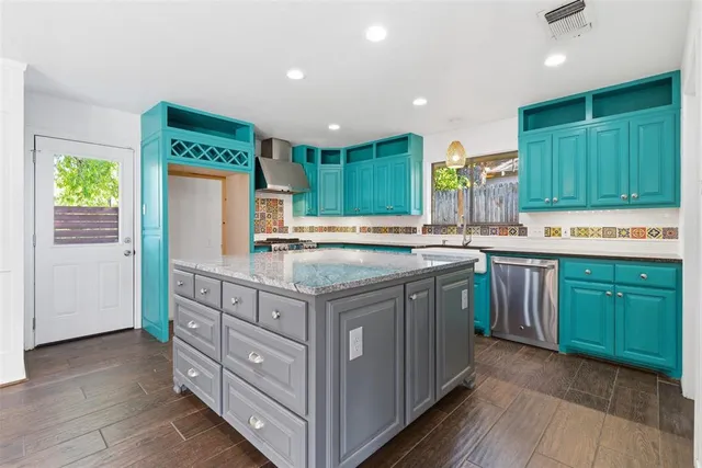 a kitchen with kitchen island granite countertop wooden cabinets and a sink