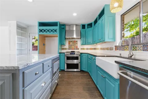 a kitchen with kitchen island granite countertop a sink counter top space stainless steel appliances and cabinets