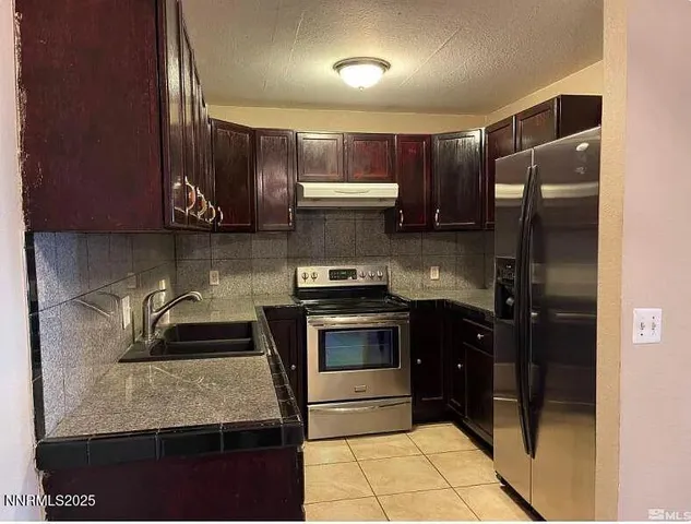 a kitchen with a refrigerator and a sink