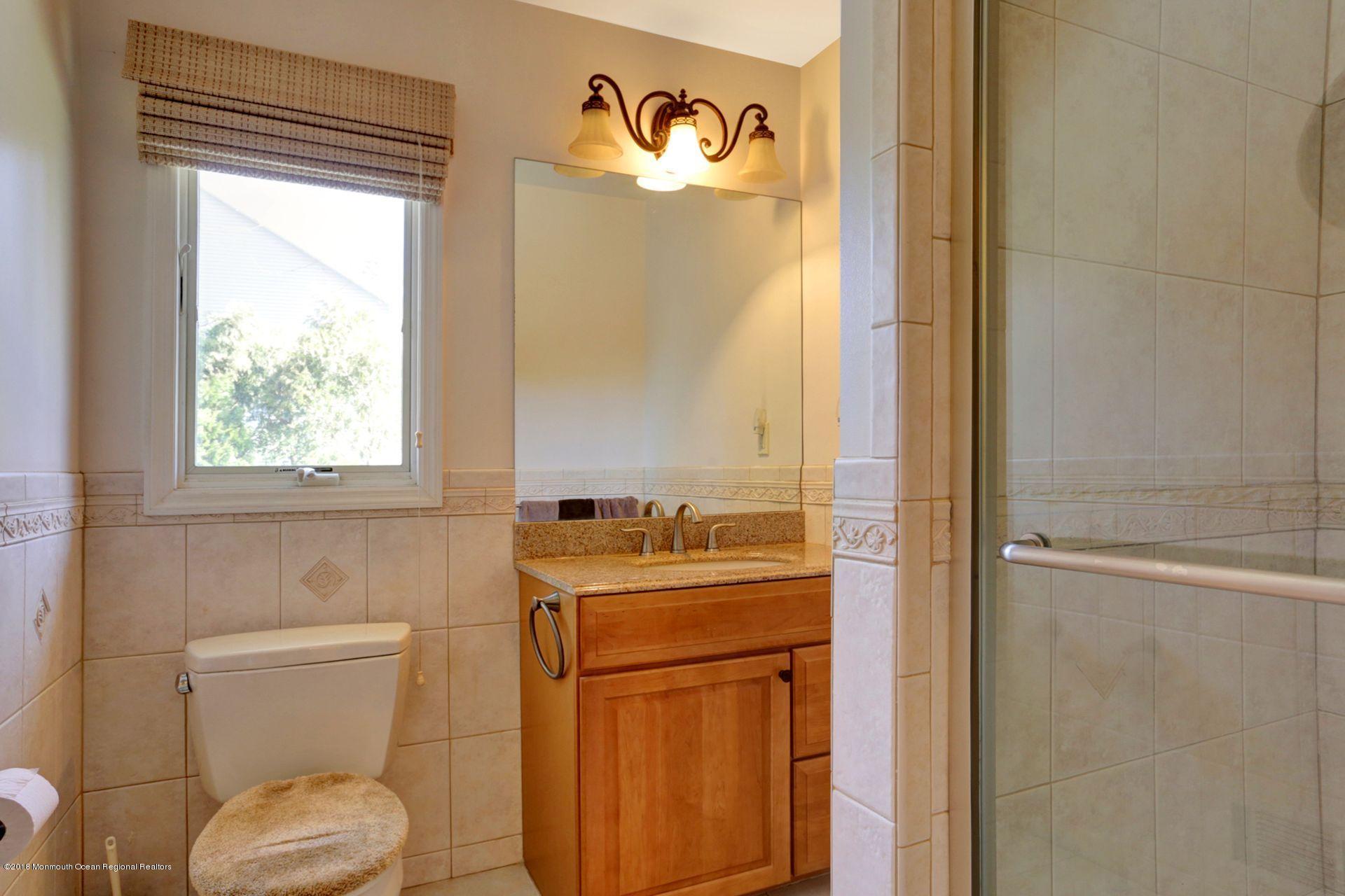 115 Crawford Road Middletown, NJ 07748 - Photo 22 of 41 a bathroom with a toilet sink vanity and mirror