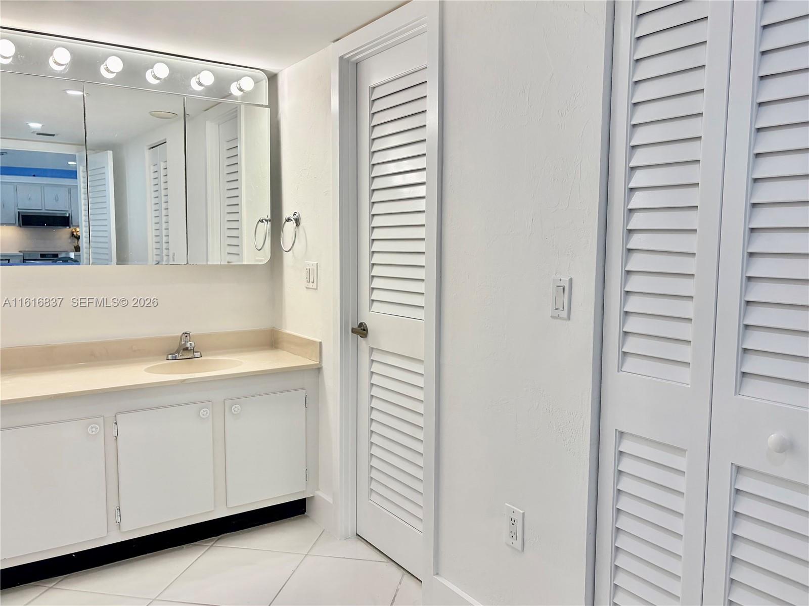 9273 Collins Avenue, Unit 507 Surfside, FL 33154 - Photo 11 of 22 a bathroom with a sink and a mirror