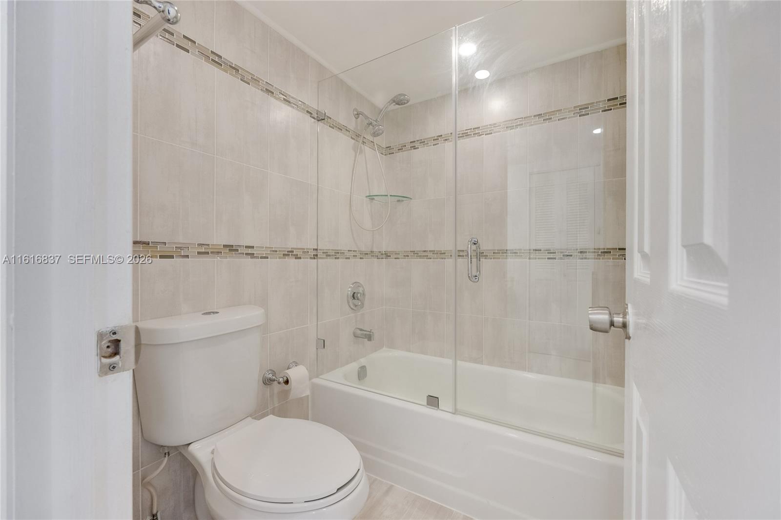 9273 Collins Avenue, Unit 507 Surfside, FL 33154 - Photo 12 of 22 a white toilet sitting next to a bath tub shower