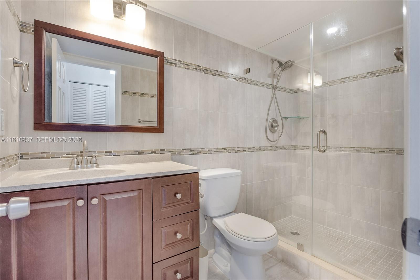 9273 Collins Avenue, Unit 507 Surfside, FL 33154 - Photo 14 of 22 a bathroom with a granite countertop sink toilet and shower