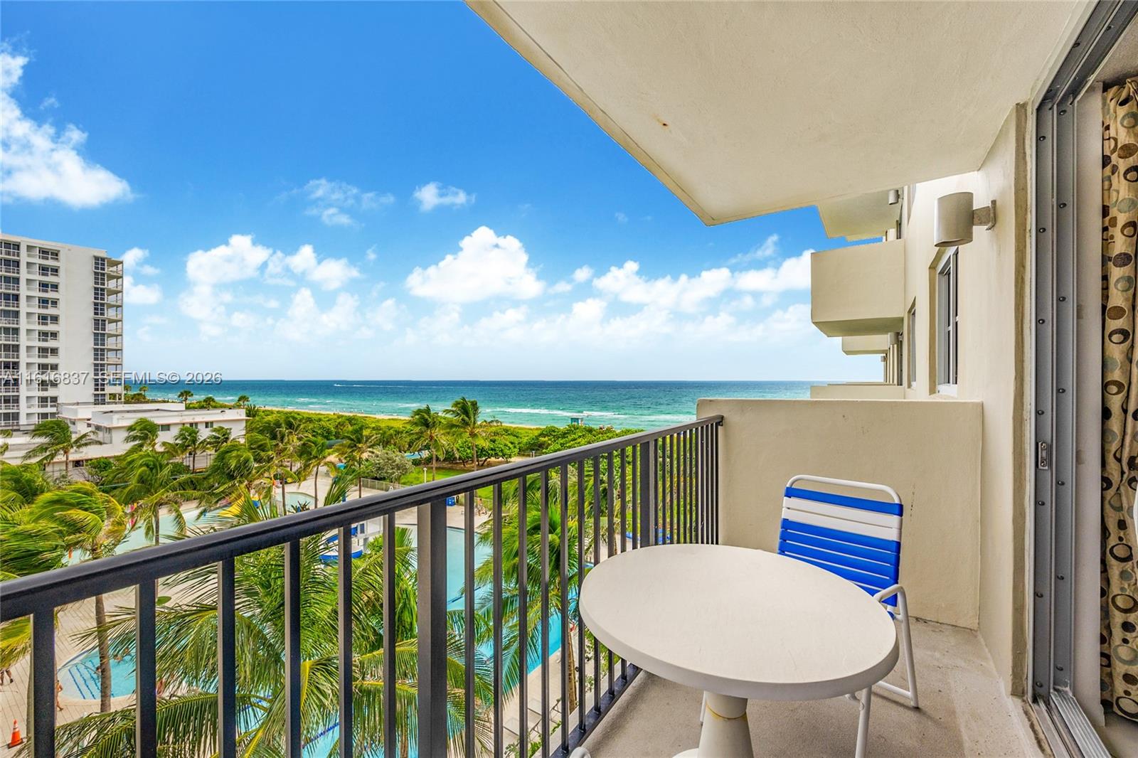 9273 Collins Avenue, Unit 507 Surfside, FL 33154 - Photo 3 of 22 a view of a balcony with chair and wooden floor