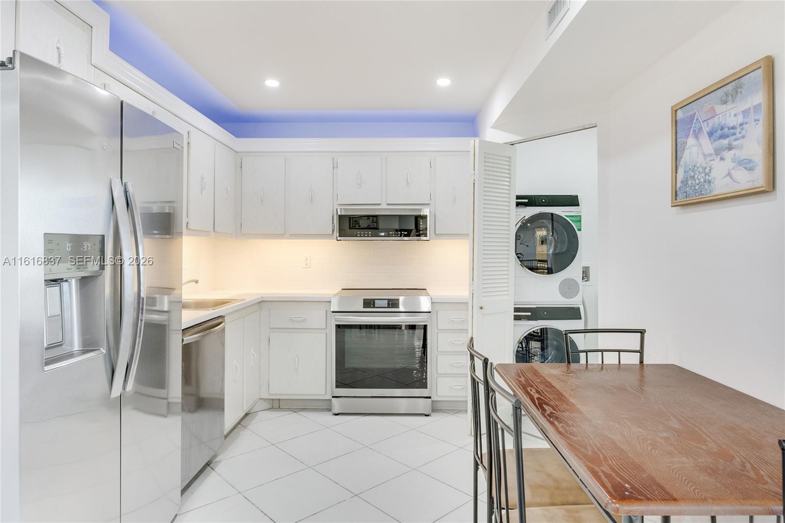 9273 Collins Avenue, Unit 507 Surfside, FL 33154 - Photo 8 of 22 a kitchen with stainless steel appliances granite countertop a stove a refrigerator and a stove