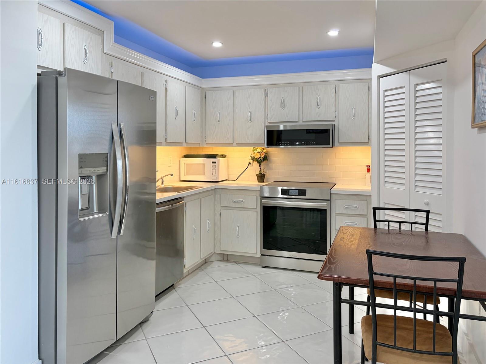 9273 Collins Avenue, Unit 507 Surfside, FL 33154 - Photo 9 of 22 a kitchen with stainless steel appliances granite countertop a refrigerator and a stove top oven