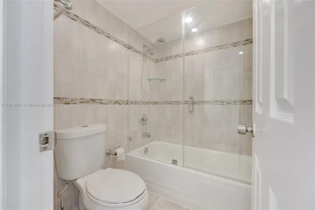 a white toilet sitting next to a bath tub shower