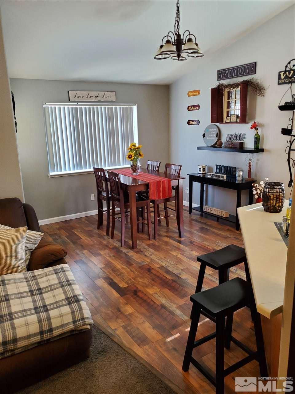 1239 Lattin Road Fallon, NV 89406 - Photo 4 of 15 a dining room with wooden floor and a chandelier