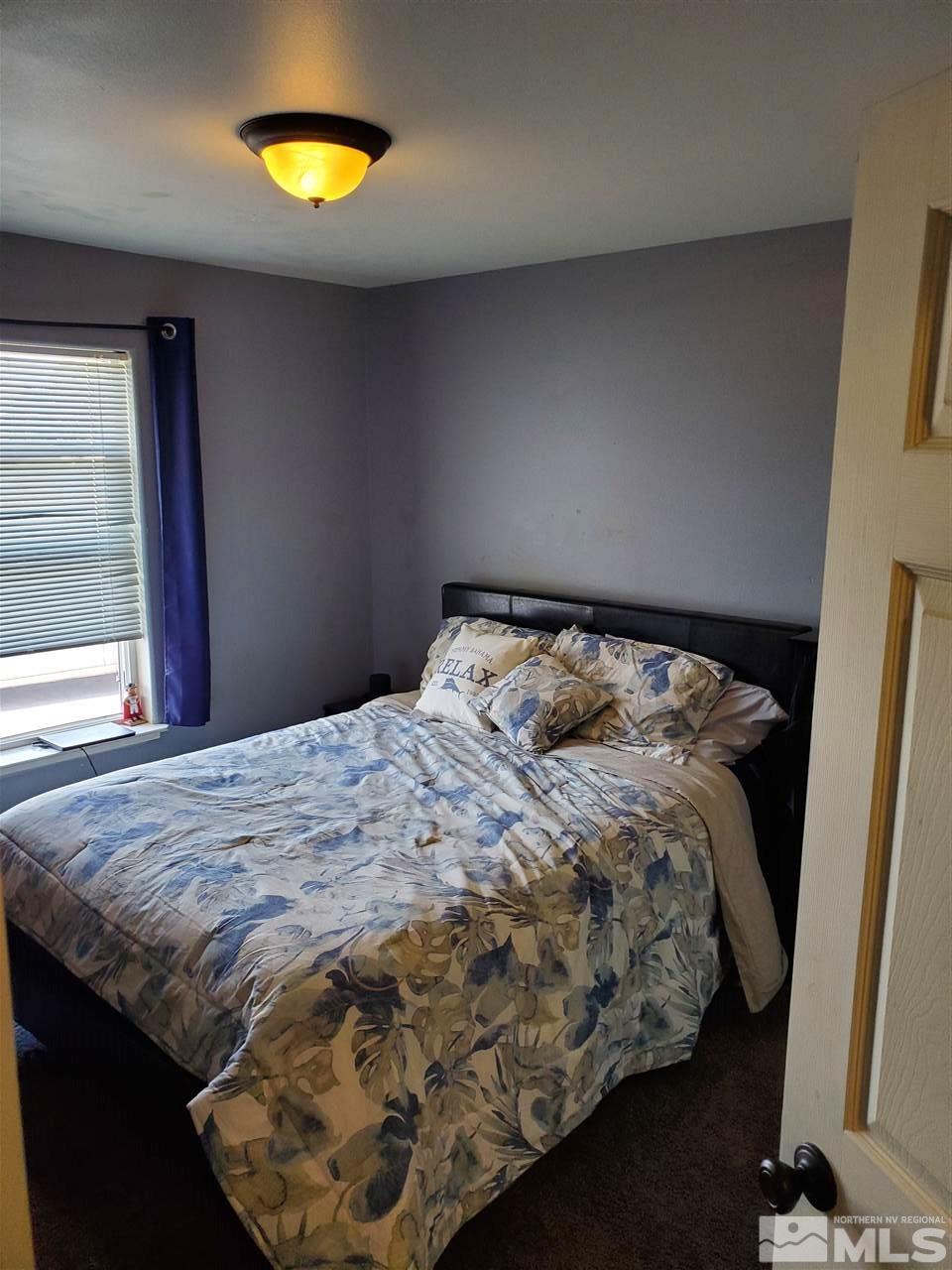 1239 Lattin Road Fallon, NV 89406 - Photo 9 of 15 a bed sitting in a bedroom next to a window