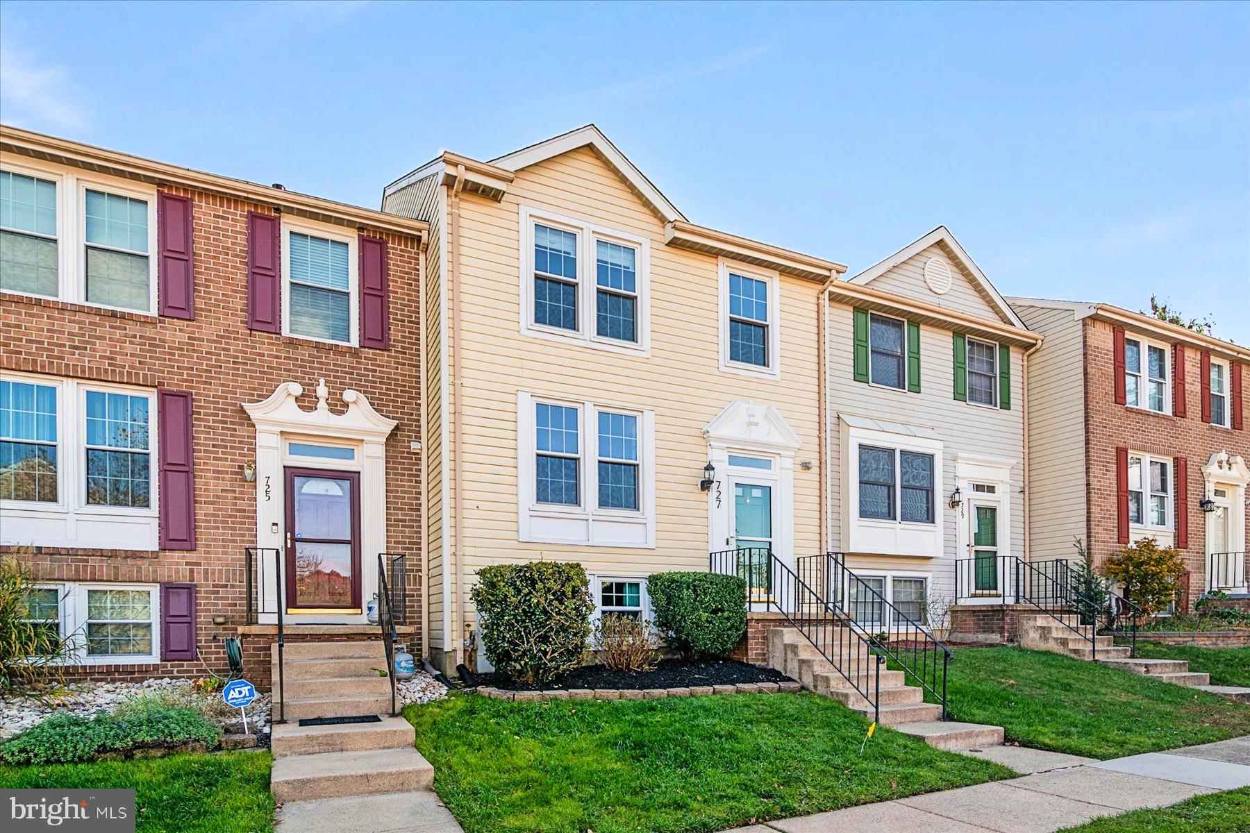 a front view of a house with yard and green space
