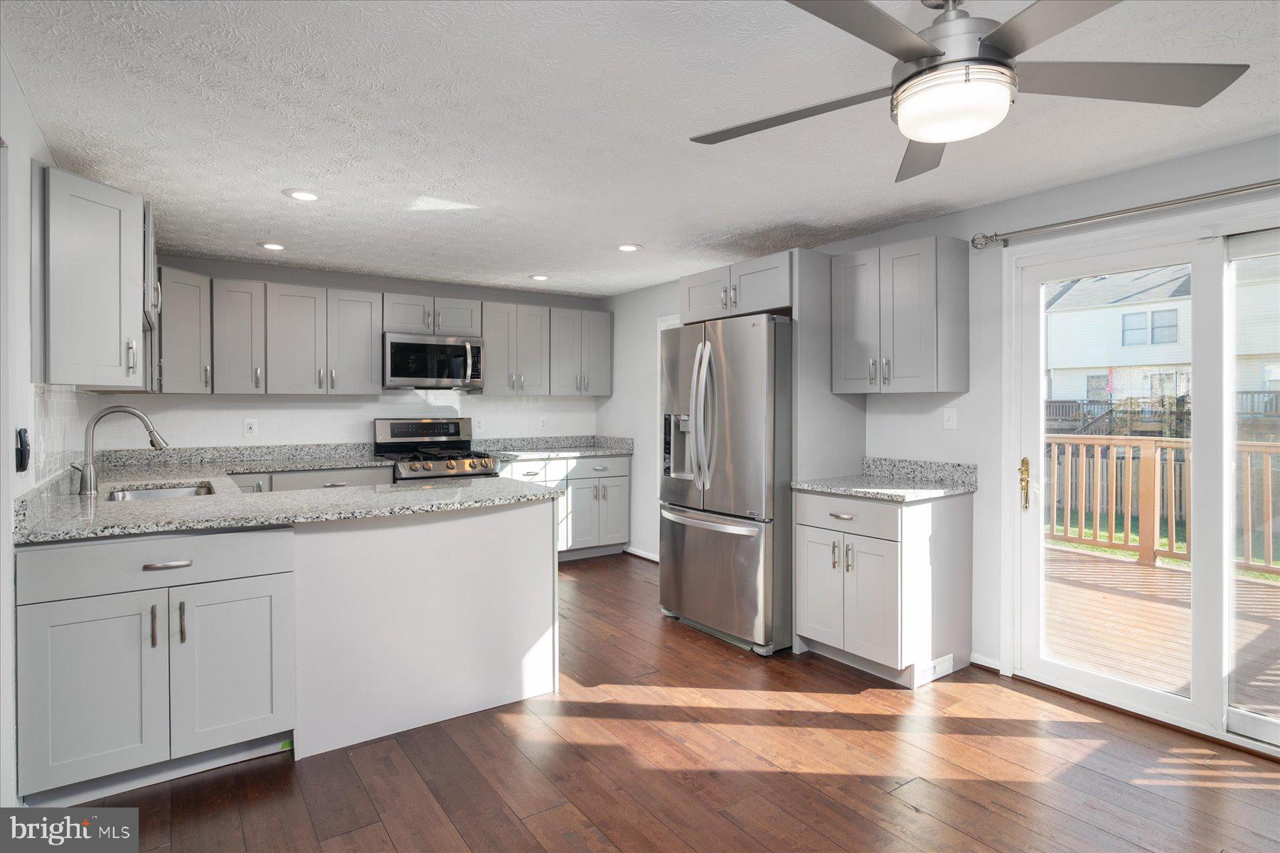 727 Dayspring Drive Odenton, MD 21113 - Photo 2 of 44 a kitchen with stainless steel appliances granite countertop a refrigerator a stove a sink and a granite counter tops with wooden floors