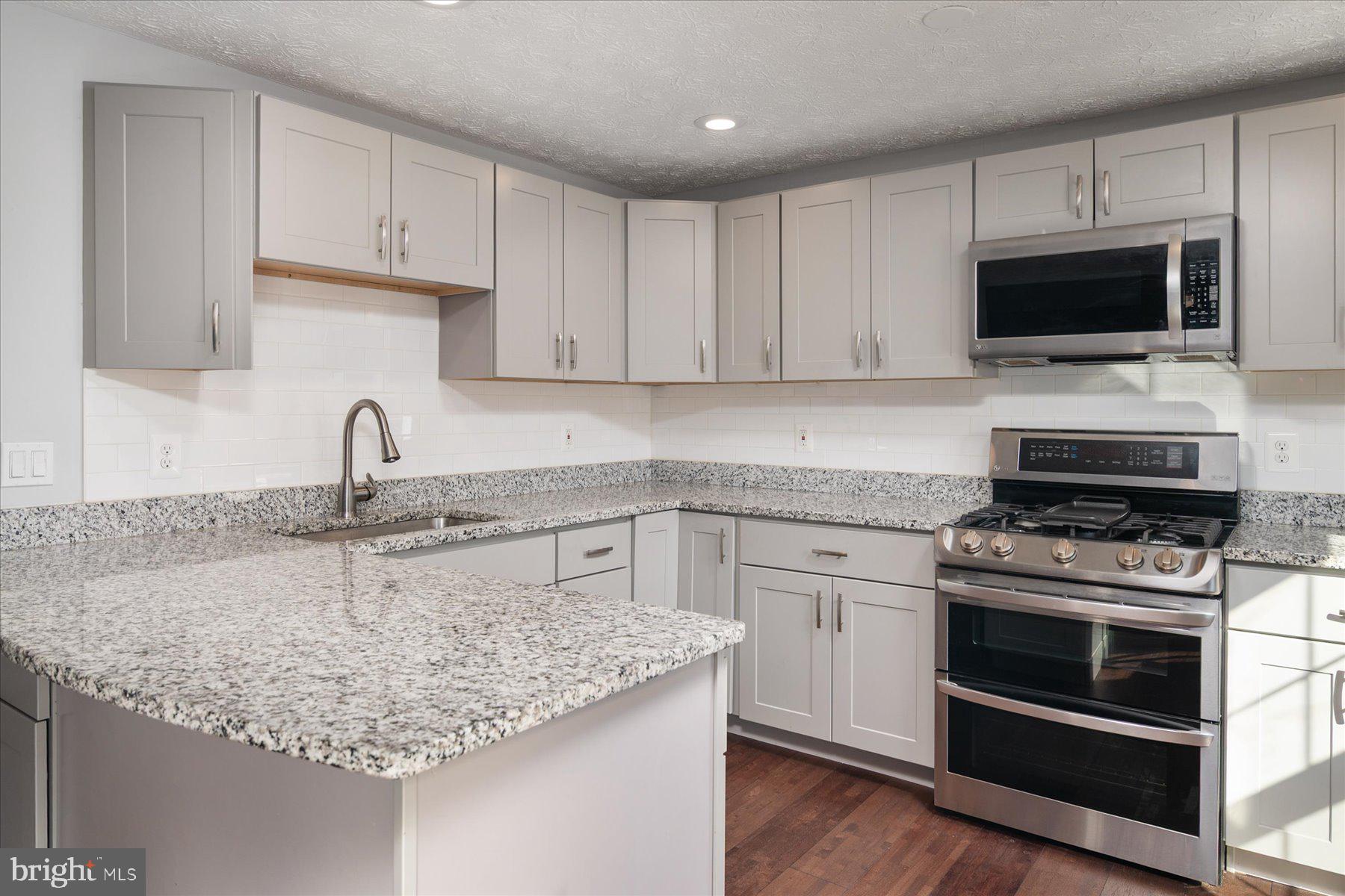 727 Dayspring Drive Odenton, MD 21113 - Photo 5 of 44 a kitchen with granite countertop a sink stainless steel appliances and white cabinets