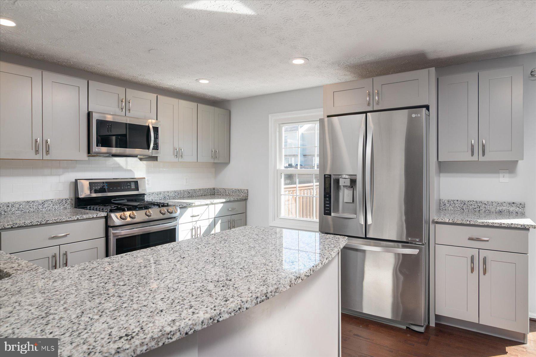 727 Dayspring Drive Odenton, MD 21113 - Photo 6 of 44 a kitchen with granite countertop a refrigerator stove and microwave