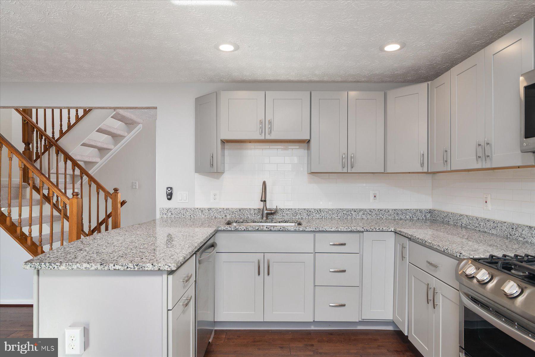 727 Dayspring Drive Odenton, MD 21113 - Photo 7 of 44 a kitchen with granite countertop a sink a stove and cabinets