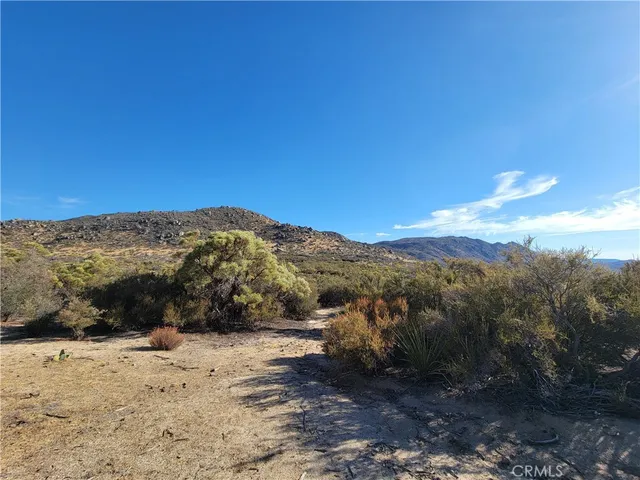 a view of a dry yard with mountains in the background