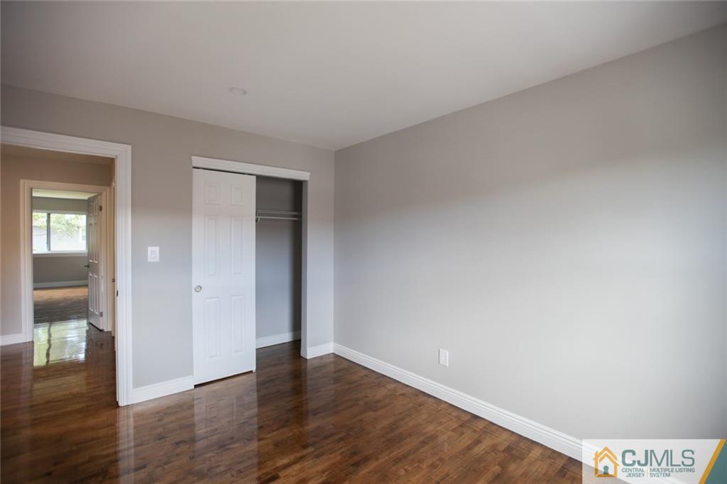 3803 Hana Road Edison, NJ 08817 - Photo 14 of 15 a view of an empty room with wooden floor and a bathroom