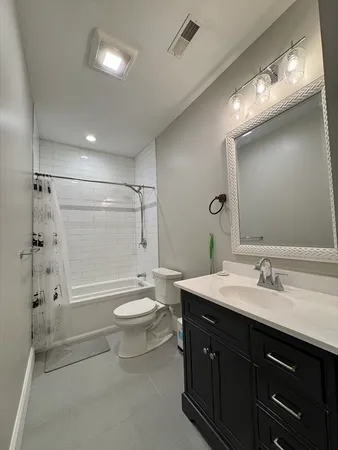 a bathroom with a double vanity sink toilet and shower