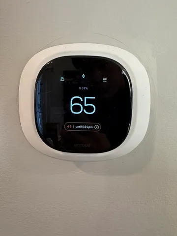 a view of a brick house with lots of windows and plants