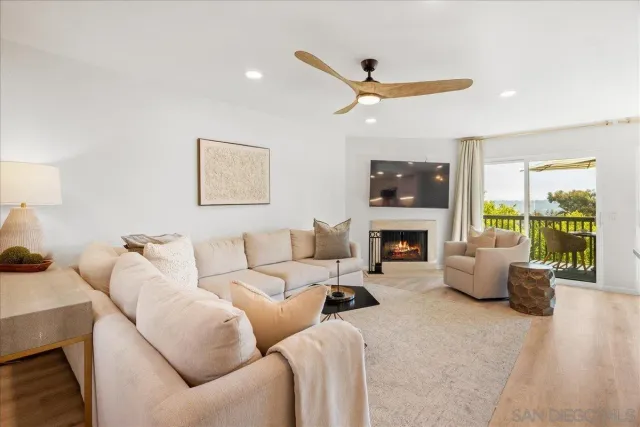 a living room with furniture a fireplace and a large window