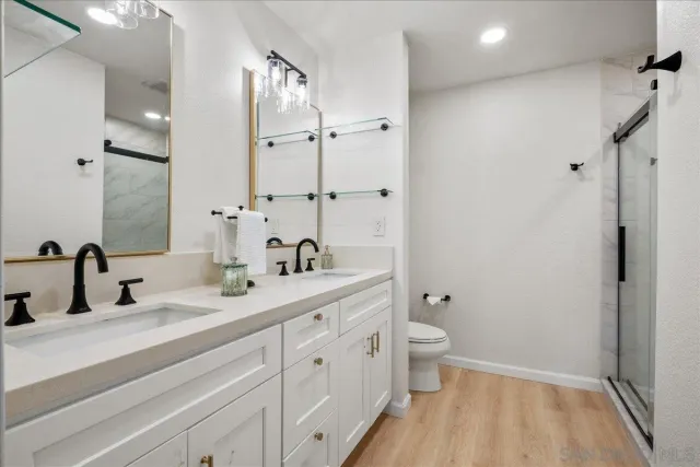 a bathroom with a double vanity sink toilet and shower