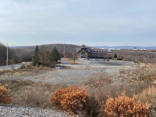 a view of a dry yard with wooden fence