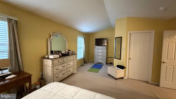 a living room with a flat screen tv a lamp and a window