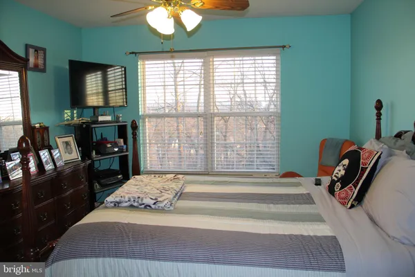 a bedroom with a bed and a flat tv screen on dresser