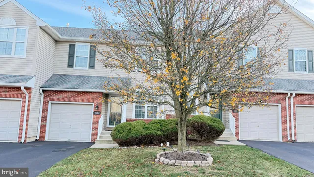 a front view of a house with a yard garage and plants