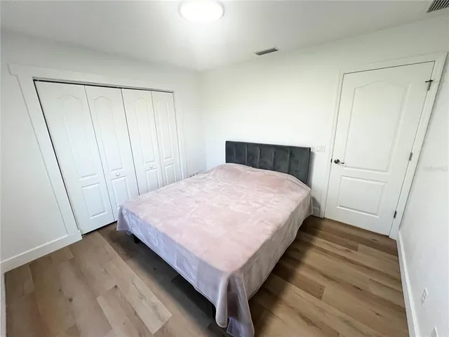 a bed sitting in a bedroom next to a bathroom