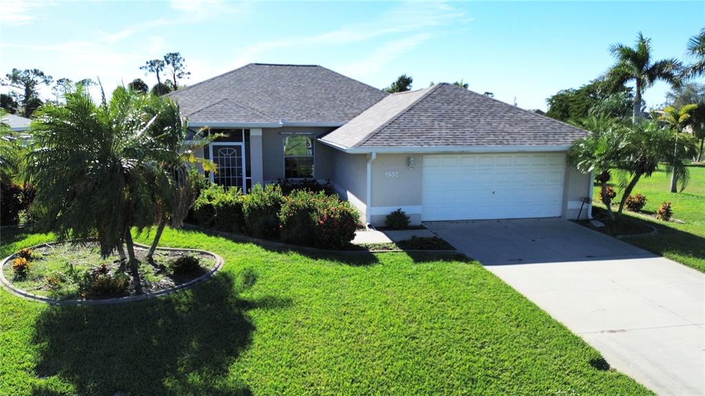 255 Medalist Road Rotonda West, FL 33947 - Photo 20 of 21 a front view of a house with a yard and potted plants