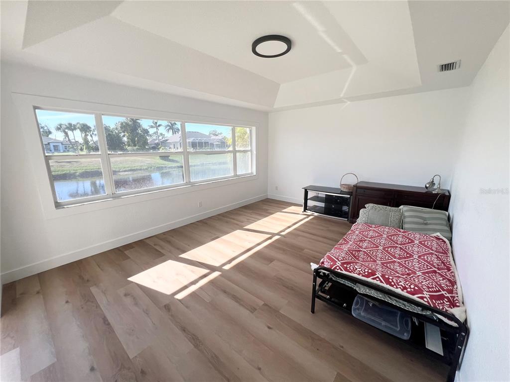 255 Medalist Road Rotonda West, FL 33947 - Photo 8 of 21 a bedroom with a bed and wooden floor