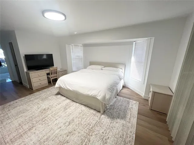 a bedroom with a bed and a flat screen tv