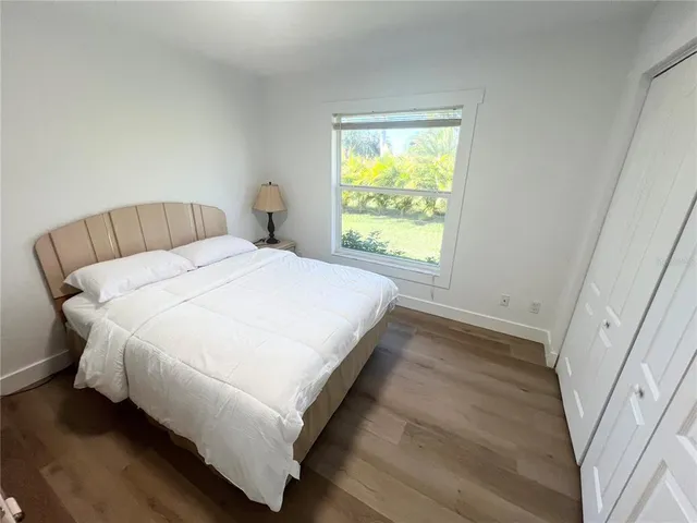 a large bed sitting in a bedroom next to a window