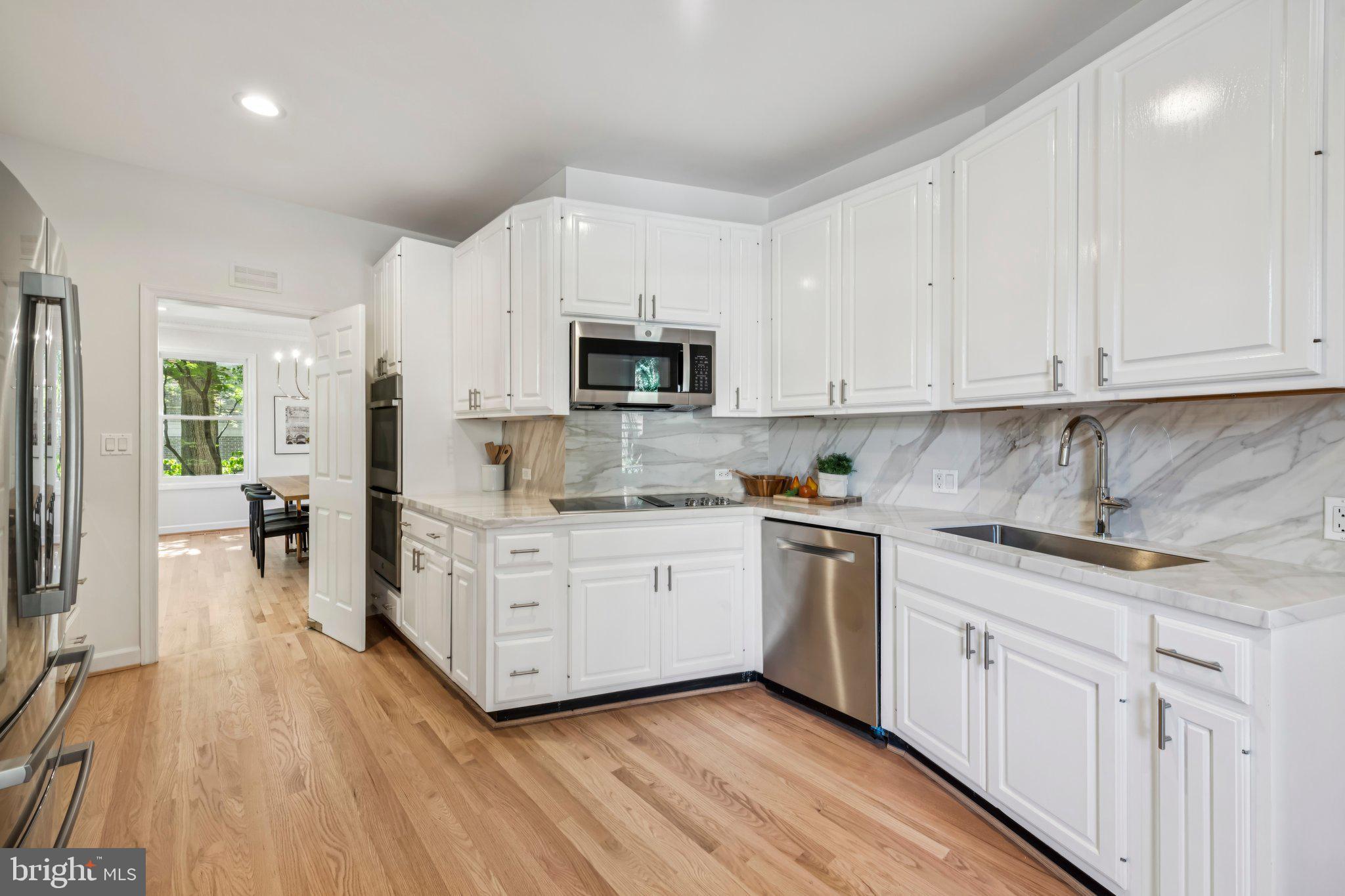 4730 Foxhall Crescent Northwest Washington, DC 20007 - Photo 11 of 37 a kitchen with stainless steel appliances white cabinets a sink a stove a refrigerator and white cabinets