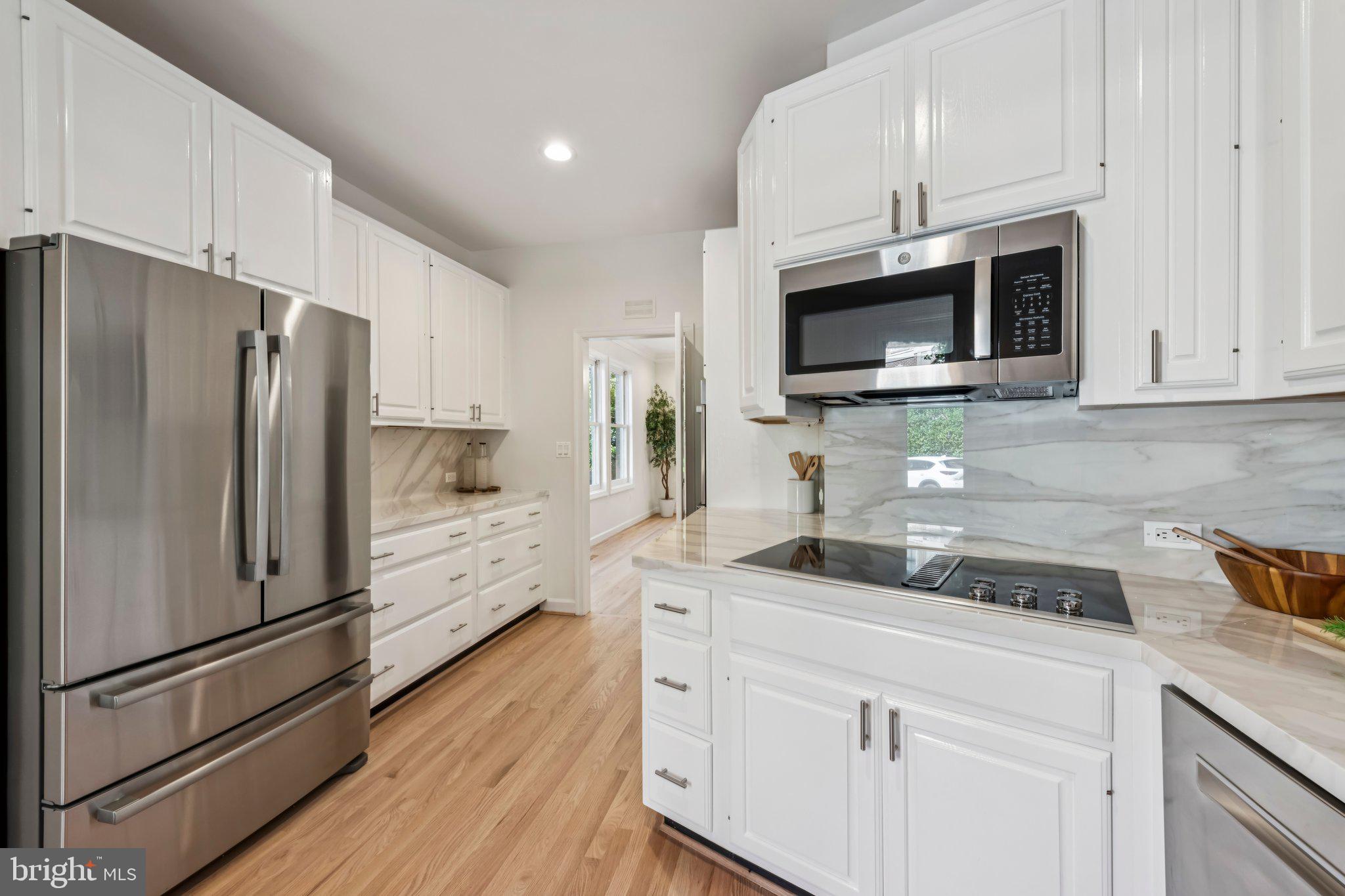4730 Foxhall Crescent Northwest Washington, DC 20007 - Photo 12 of 37 a kitchen with cabinets stainless steel appliances a sink and wooden floor
