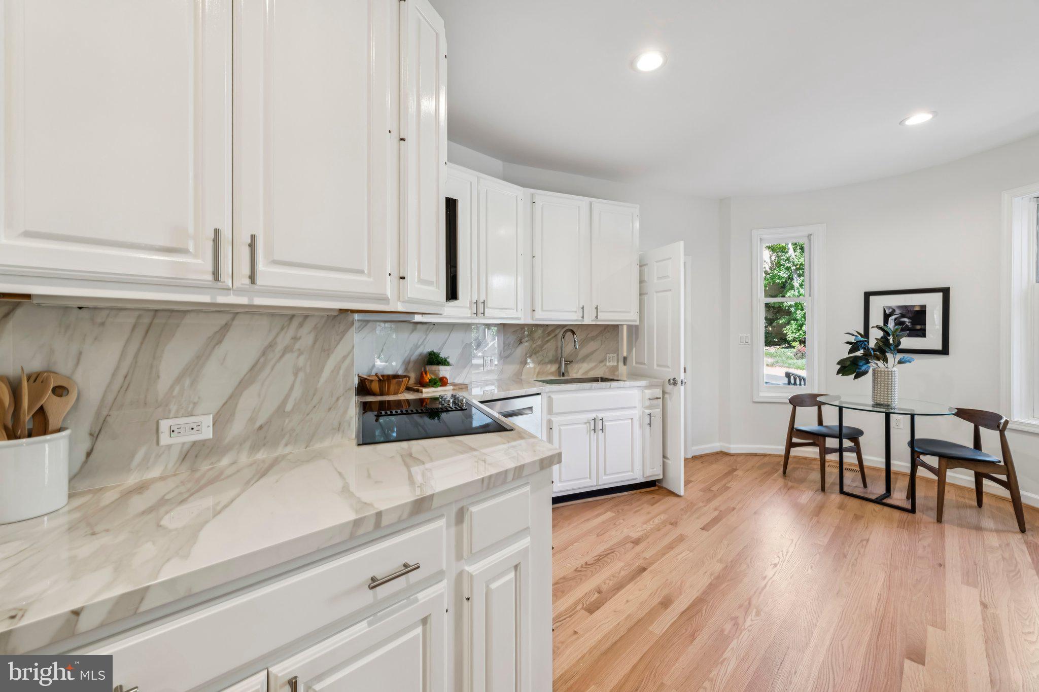 4730 Foxhall Crescent Northwest Washington, DC 20007 - Photo 13 of 37 a kitchen with granite countertop a stove a sink a dining table and chairs