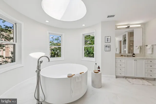 a bathroom with a tub sink and mirror
