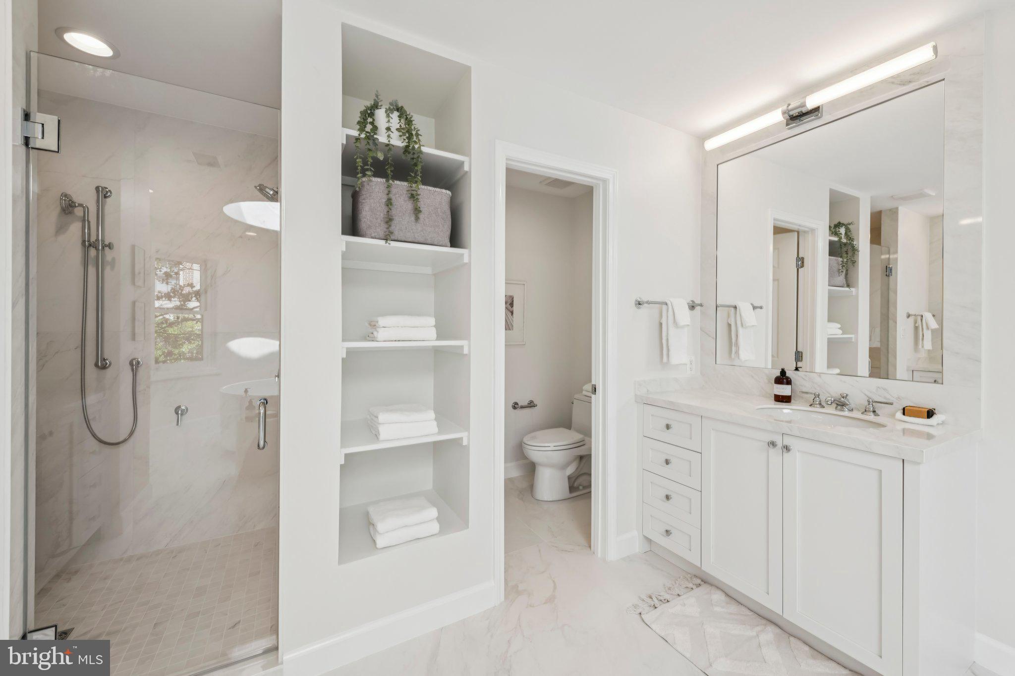 4730 Foxhall Crescent Northwest Washington, DC 20007 - Photo 21 of 37 a bathroom with a glass shower door a sink and a mirror