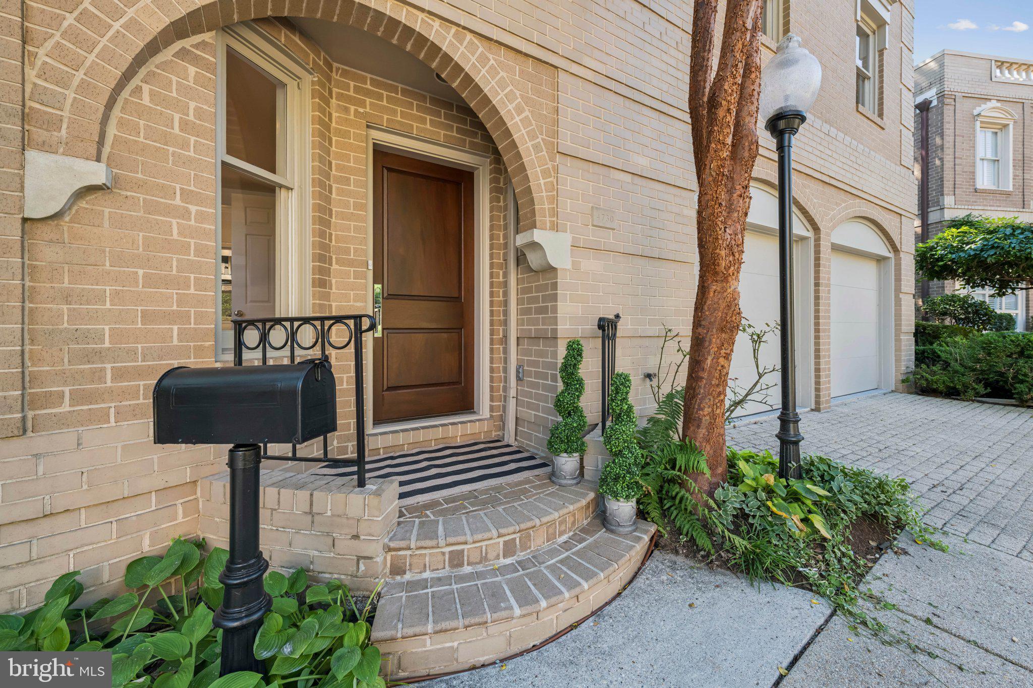 4730 Foxhall Crescent Northwest Washington, DC 20007 - Photo 3 of 37 a view of a brick house with potted plants