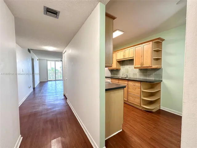 a kitchen with kitchen island granite countertop a sink and cabinets