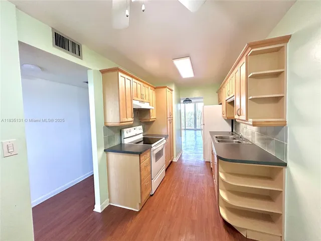 a kitchen with stainless steel appliances granite countertop a sink stove and wooden floor