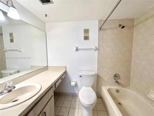 a bathroom with a granite countertop sink toilet a mirror and shower