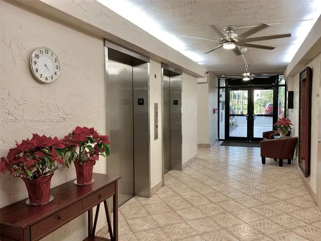 a view of a hallway with furniture and a chandelier