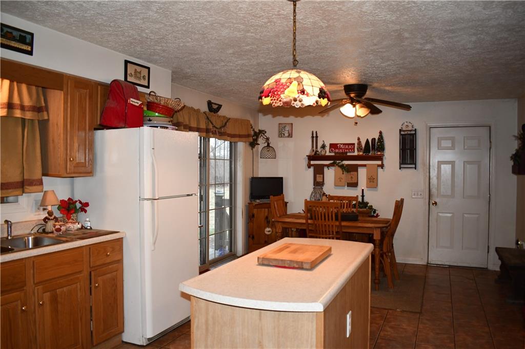 74 Tr784 Burgettstown, PA 15021 - Photo 6 of 22 a kitchen with a refrigerator a microwave a dining table and chairs
