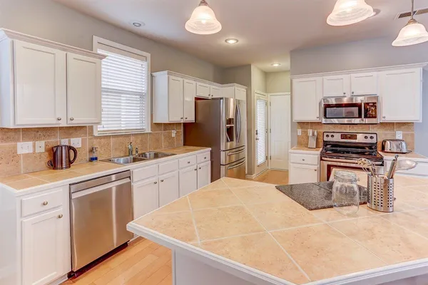 a kitchen with stainless steel appliances a refrigerator sink and cabinets