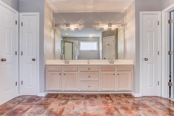 a spacious bathroom with a mirror a shower and vanity