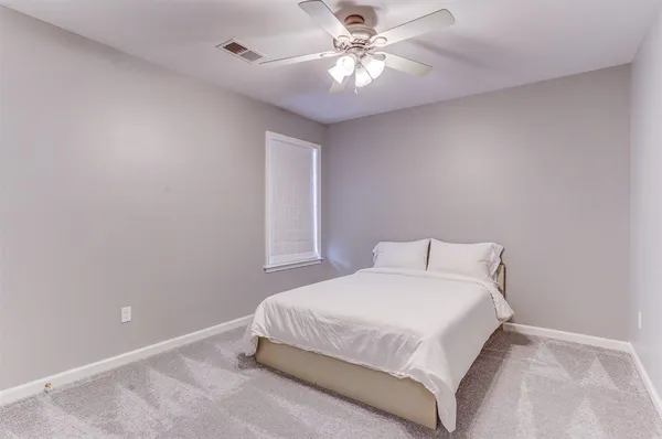 a bedroom with a large bed and a chandelier