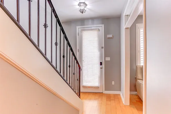 a view of a hallway with wooden floor and staircase
